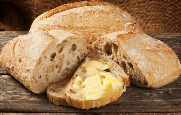 Raw butter spread on a slice of fresh sourdough bread