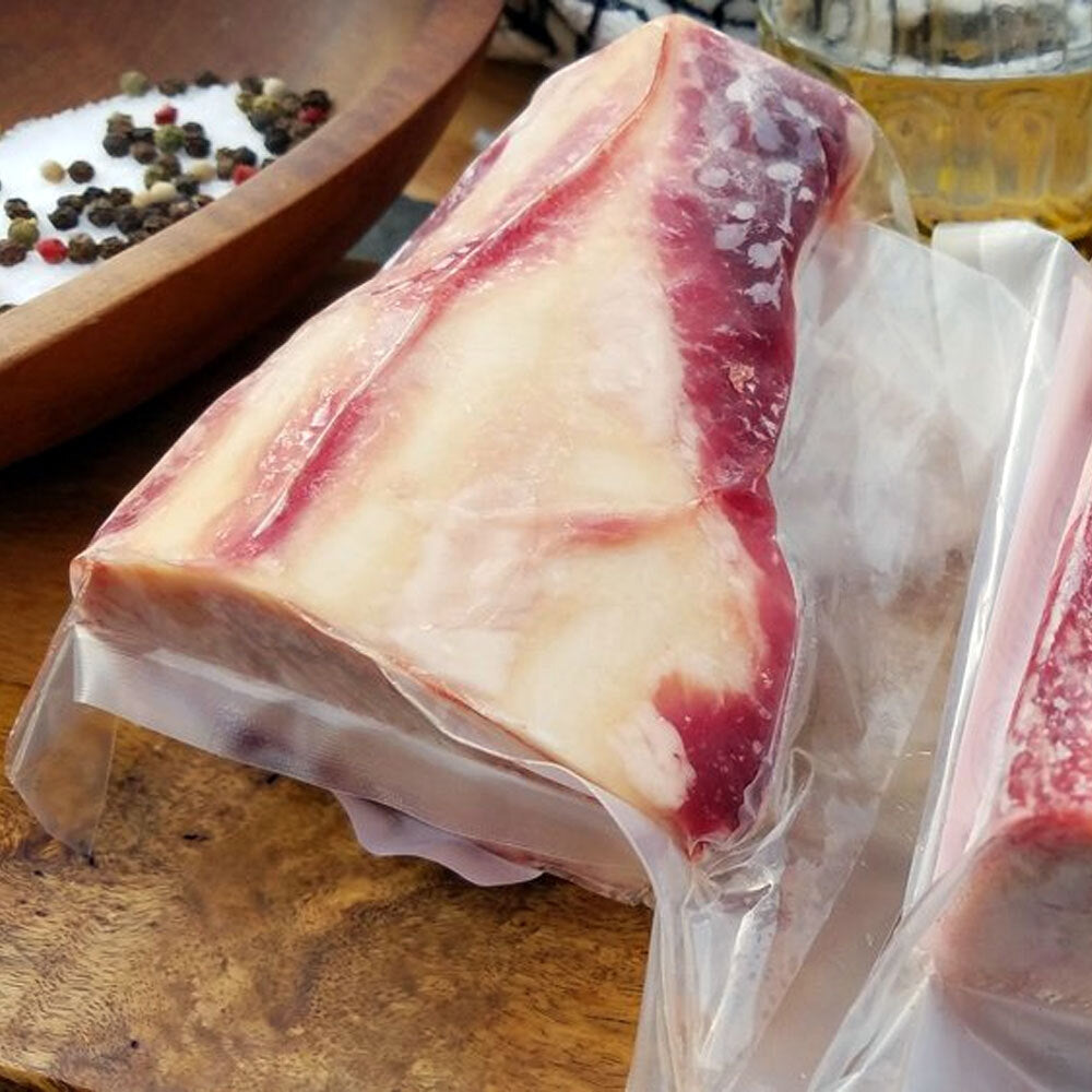 Packaged raw marrow bones sliced lengthwise, ideal for roasting and spreading