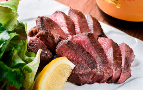 Cooked beef tongue sliced medium rare on plate, from grassfed pasture-raised cattle at Tyner Pond Farm