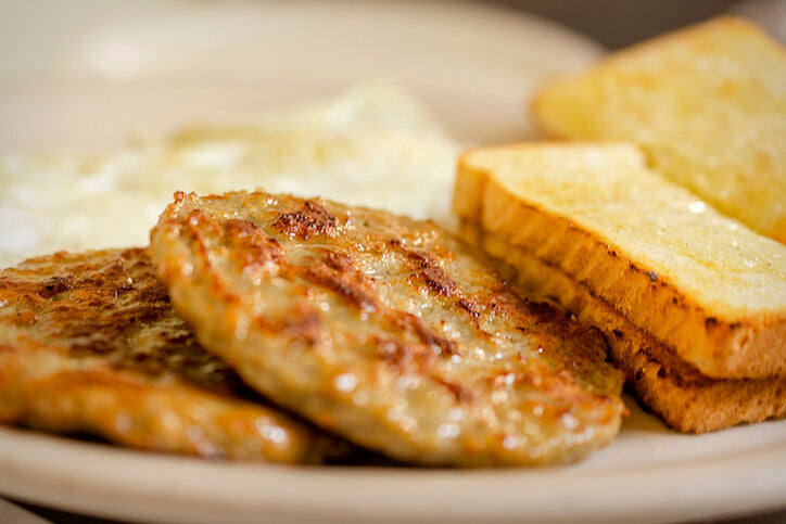 Cooked sausage patties served with toast, made from local pork breakfast sausage