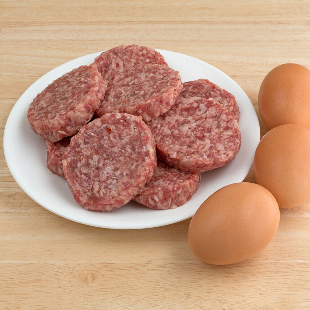 Raw breakfast sausage patties on plate, ready to cook, made from local pork