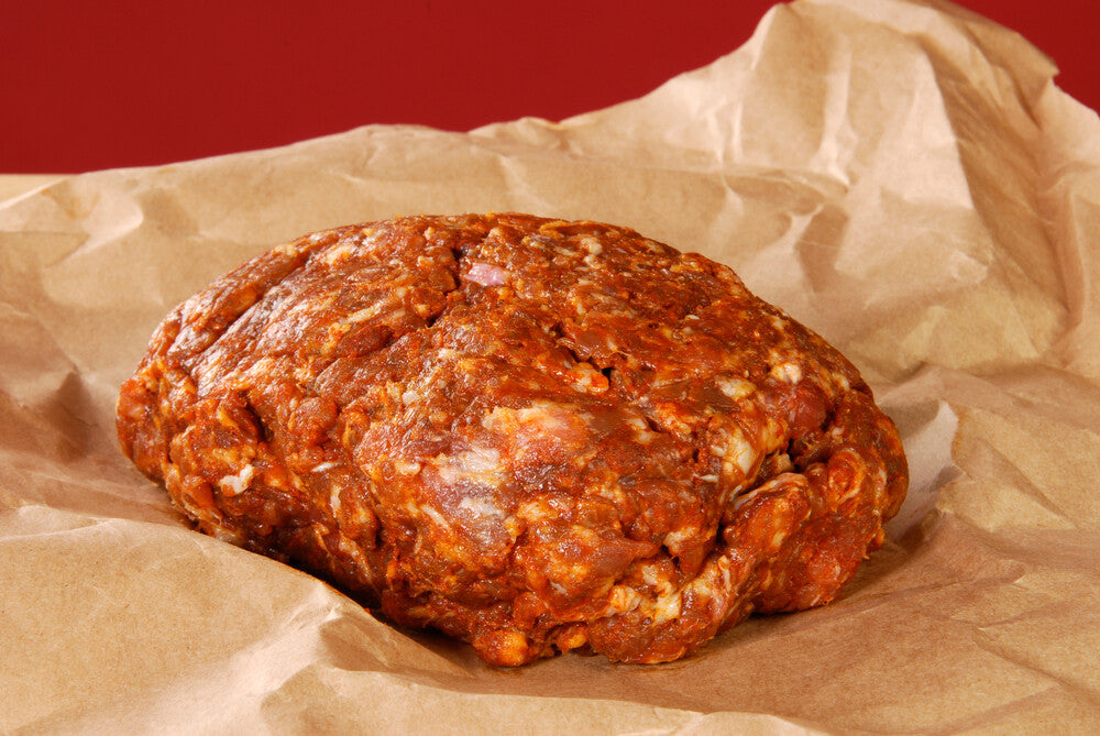 Raw Cajun-style pork sausage on butcher paper, ground and ready to cook
