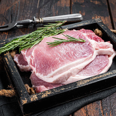 Raw boneless thin pork chops on butcher paper, trimmed and ready to cook
