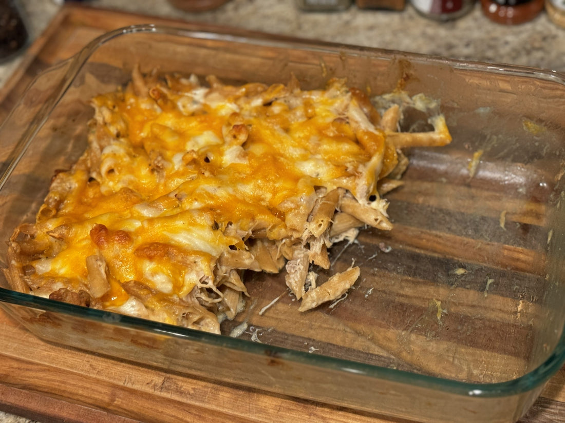 Half-eaten homemade Chicken Alfredo Casserole with melted cheese, featuring pasture-raised chicken from Tyner Pond Farm, fresh from the oven.