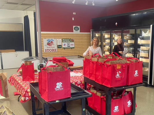 Two team members of Tyner Pond Farm preparing orders in the farm store with red branded bags