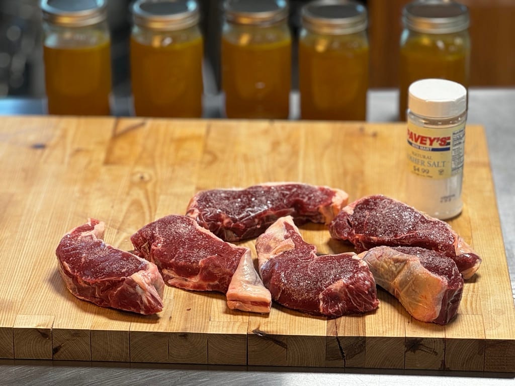 Grass-fed steaks from Tyner Pond Farm dry brining with natural sea salt for enhanced tenderness and taste.