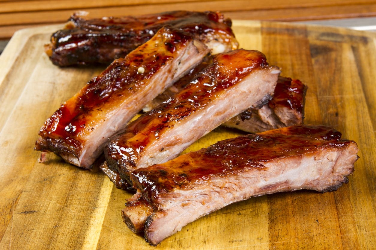Deliciously glazed grass-fed beef short ribs from Tyner Pond Farm, arranged on a wooden cutting board