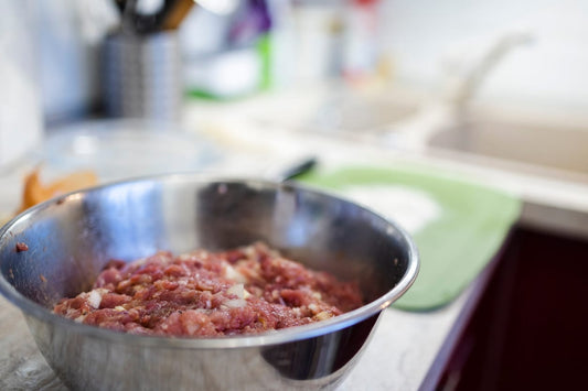 Bowl of freshly prepared raw pet food with pasture-raised meat, ideal for biologically appropriate raw feeding for dogs and cats