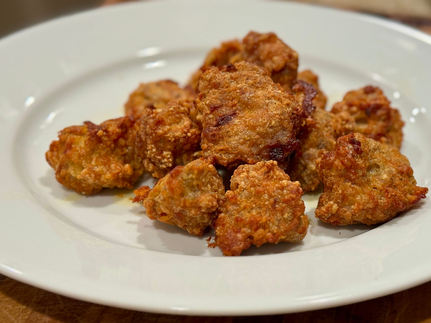Homemade low-carb chicken nuggets made with Tyner Pond Farm pasture-raised ground chicken, golden brown and crisp on a white plate