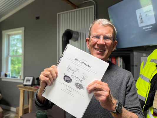 Chris Baggott holding the Tyner Pond Farm cookbook with 48 keto diet recipes and practical meal ideas.