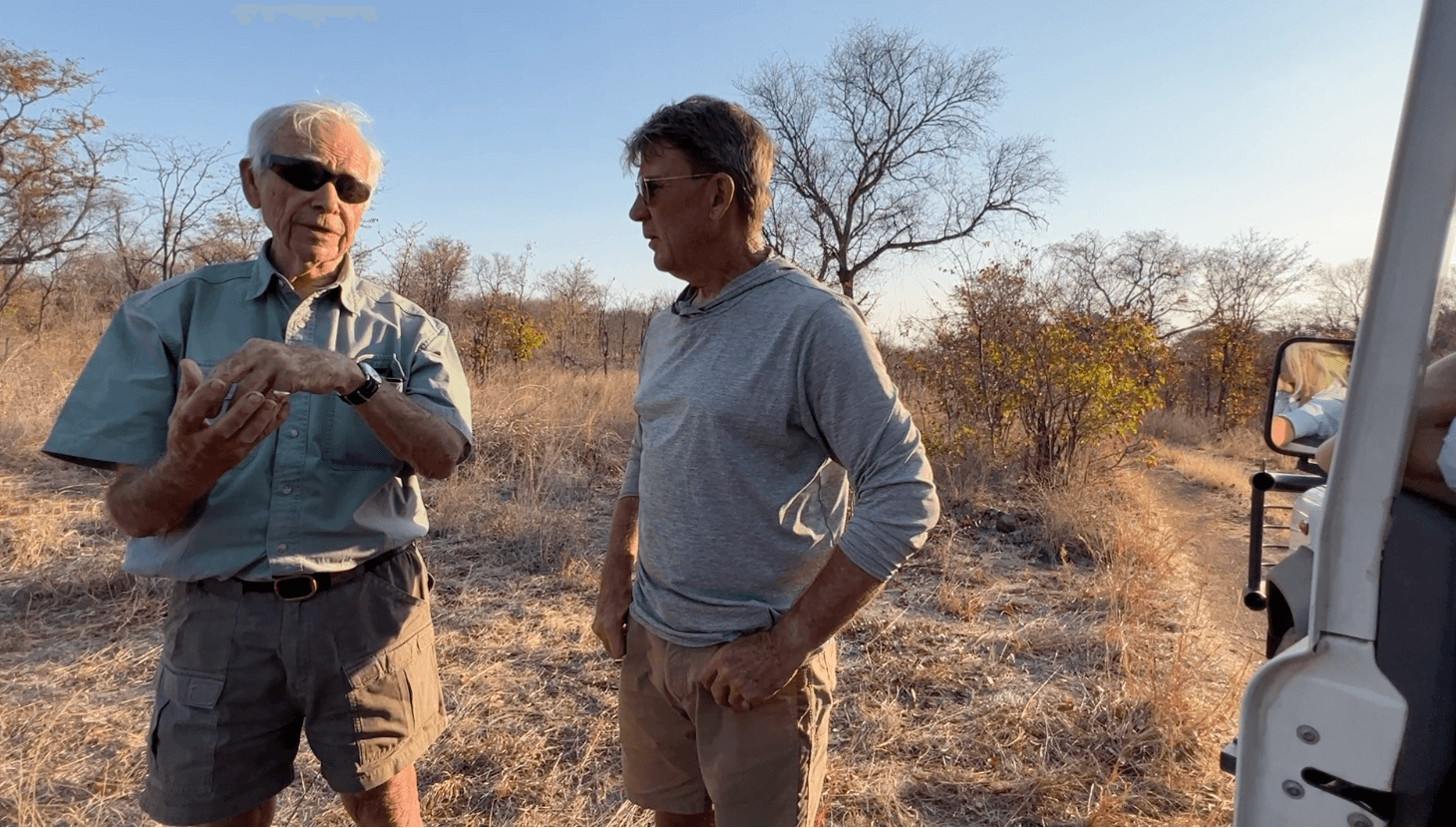 Alan Savory and Chris Baggott studying holistic management practices in an open field in Zimbabwe