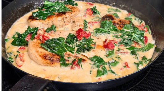 Creamy Tuscan chicken with kale and sun-dried tomatoes in a skillet