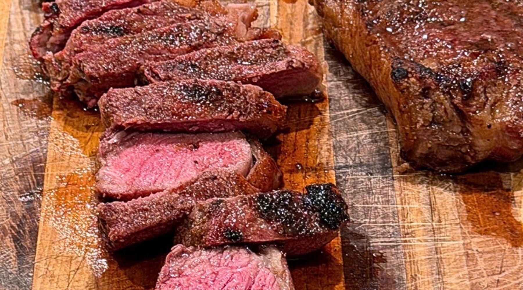 Sliced 100% grass-fed steak on a wooden cutting board, illustrating nutrient-dense protein for healthy aging. Tyner Pond Farm, Indiana
