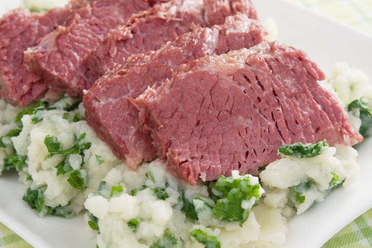 Grass fed corned beef brisket slices served over traditional Irish colcannon potatoes with cabbage.