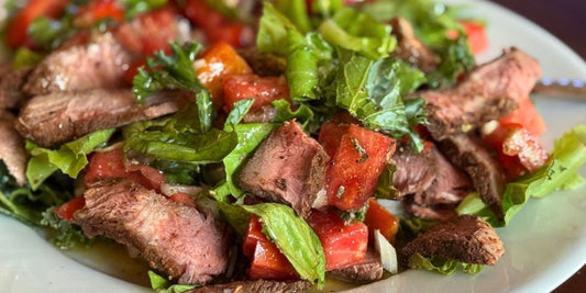 Grassfed beef salad with leafy greens and olive oil dressing representing nutrient-dense real food instead of supplements