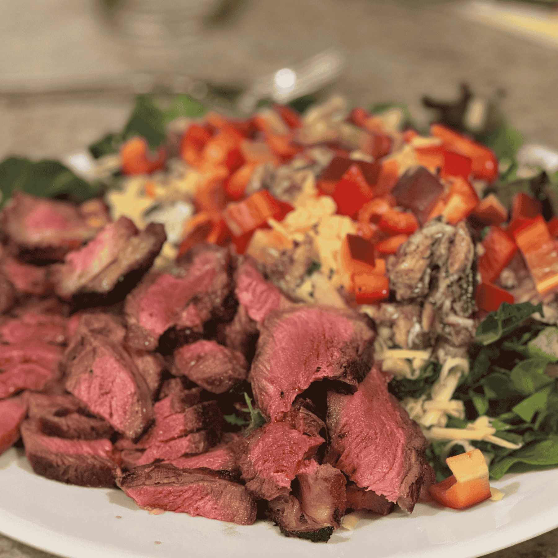 Grass-fed steak served with a large salad, illustrating a high-protein, unprocessed meal.