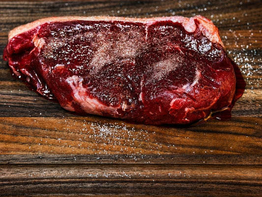 Grass-fed steak seasoned with salt for a 12-hour dry brine before cooking at Tyner Pond Farm