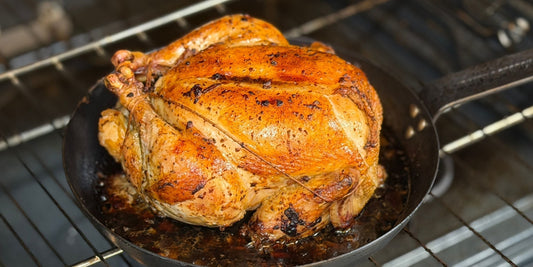 Finished Julia Child–inspired Poulet Rôti made with a Tyner Pond Farm pasture-raised whole chicken in a cast iron roasting pan.