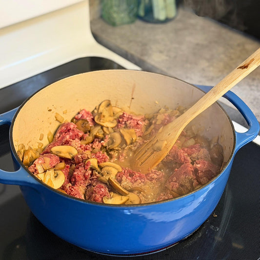 Grass-fed ground beef, mushrooms, and onions cooking in a blue Dutch oven for a keto stroganoff recipe from Tyner Pond Farm in Indiana.