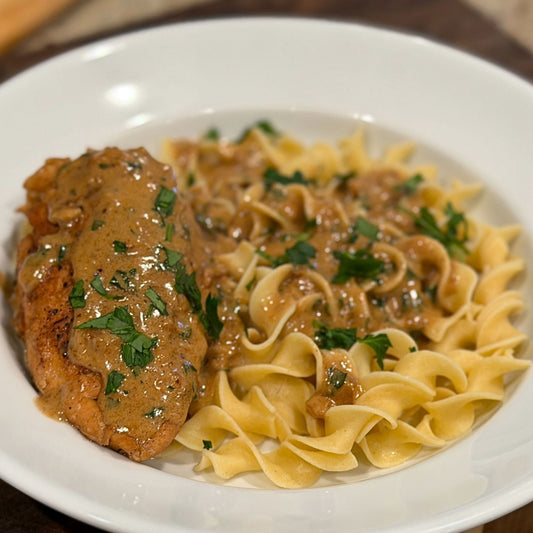 Pasture-raised chicken in cream sauce with parsley served over egg noodles for poulet à la crème.