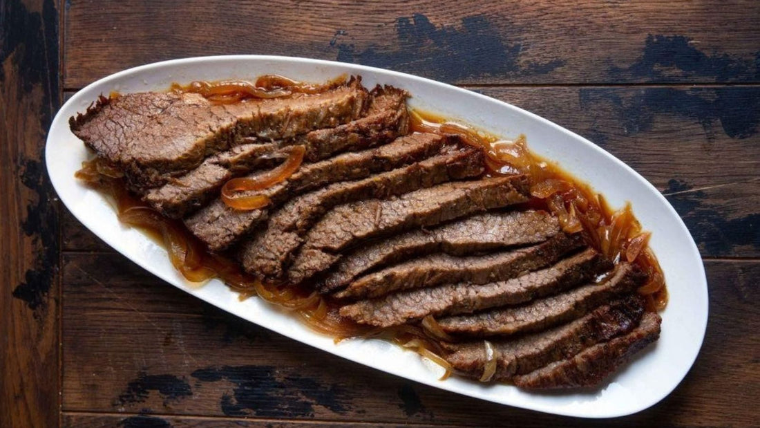 Sliced braised beef brisket served on a white plate.