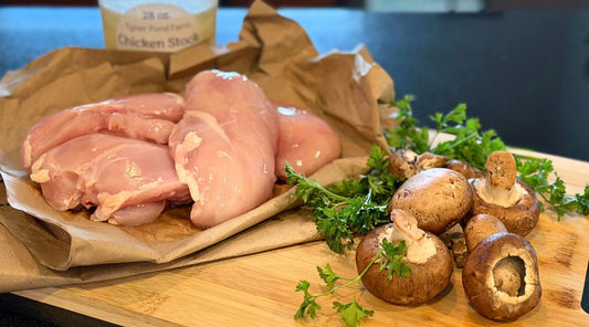 Tyner Pond Farm pasture-raised chicken breasts with mushrooms, fresh parsley, and homemade chicken stock ready for a special dinner.