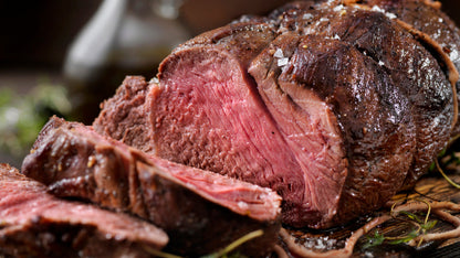 Thin slices of rare grassfed rump roast, showing lean texture and grain