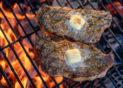 Overhead view of grassfed New York Strip Steaks grilling over open flame, raised on pasture at Tyner Pond Farm in Indiana