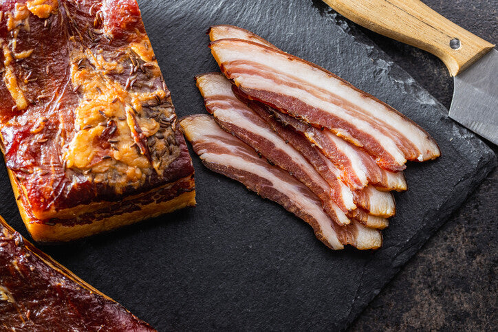 Fresh bacon being sliced from whole pork belly, made from pastured pork at Gunthorp Farms
