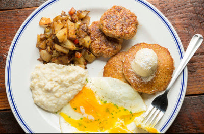 Top-down view of breakfast plate with maple sausage, fried eggs, and toast