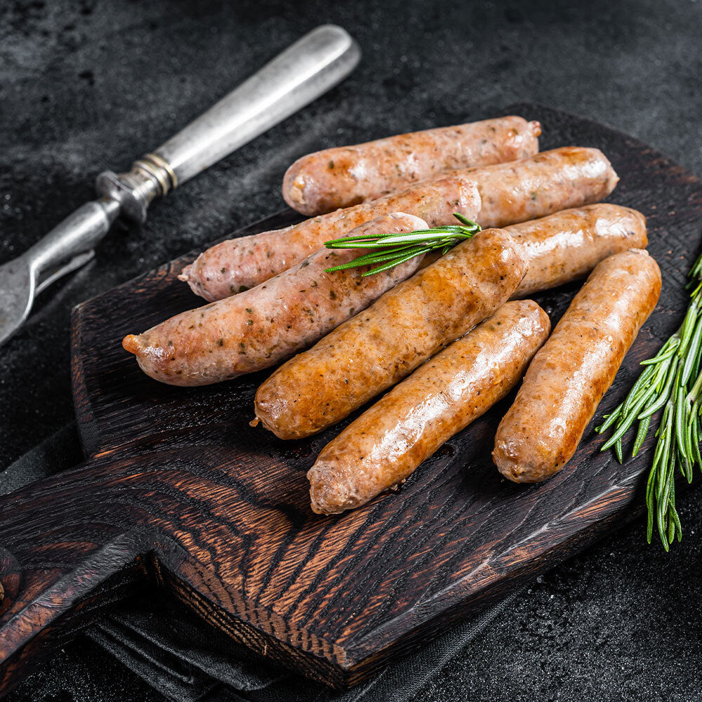 Cooked Philly cheesesteak brats on wooden serving platter, ready to eat