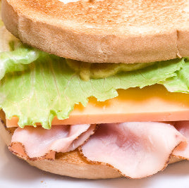 Side view of cold sandwich with shaved ham, lettuce, and cheese