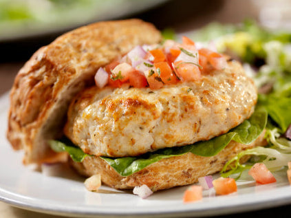 Cooked ground chicken burger on bun, made from pasture-raised chicken