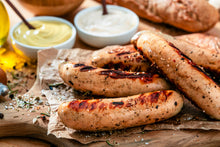 Cooked bratwurst sausages on cutting board with mustard and ketchup, pastured pork from Gunthorp Farms