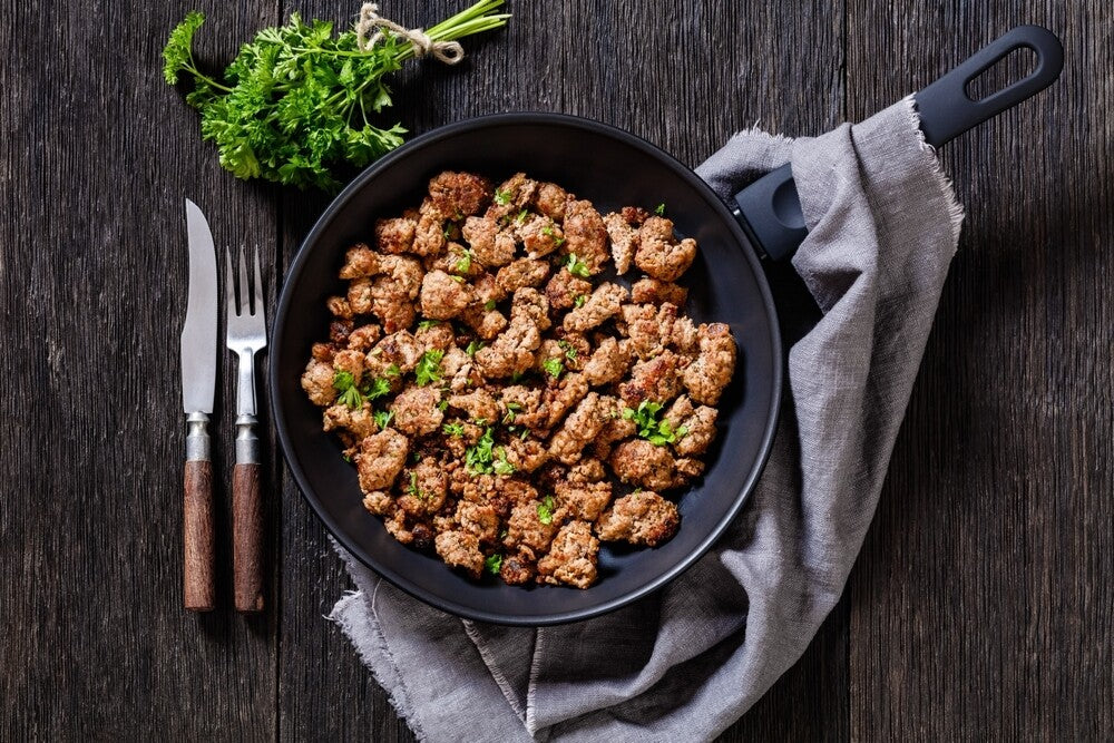 Top-down view of cooked salt and pepper pork sausage in cast iron skillet