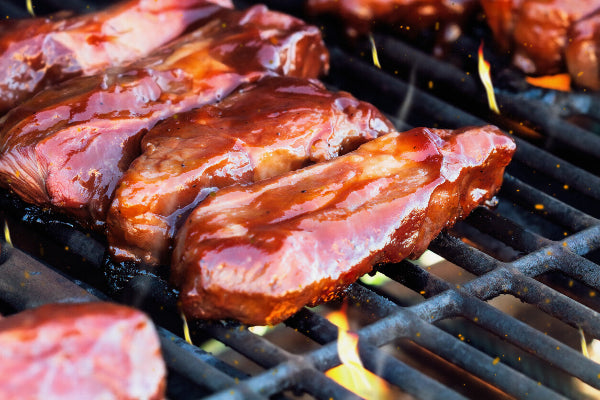Country style boneless pork ribs on grill with barbecue sauce, cooked from local pork