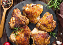 Cooked pasture-raised chicken thighs plated and ready to serve, crisp skin from outdoor-raised birds