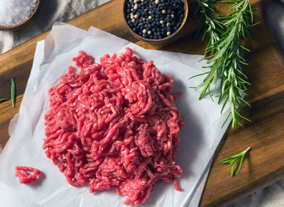 Raw grassfed ground beef on wooden cutting board, sourced from pasture-raised cattle at Tyner Pond Farm in Indiana
