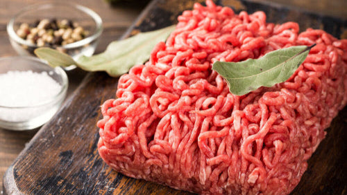 Raw grassfed ground chuck with 80/20 lean ratio, prepared on a wooden cutting board