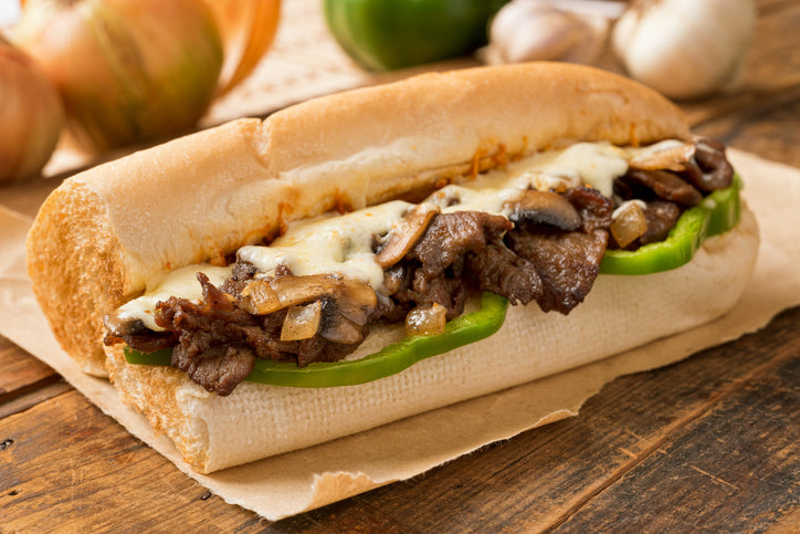Cooked grassfed ribeye sliced for Philly-style cheesesteak with melted cheese
