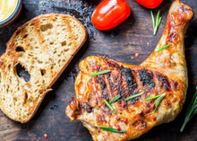 Cooked chicken leg quarter with grill marks, top-down view showing crisped skin