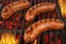 Mild Italian sausage grilling on barbecue, browned and ready to serve