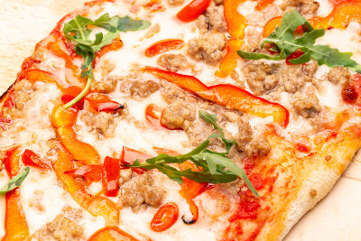 Pizza topped with hot Italian sausage and melted cheese, viewed from above