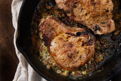 Pork chops frying in a pan, browned and sizzling, pasture-raised pork from Gunthorp Farms