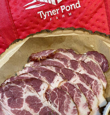 Raw sliced cottage bacon on platter, lean and round from shoulder cut