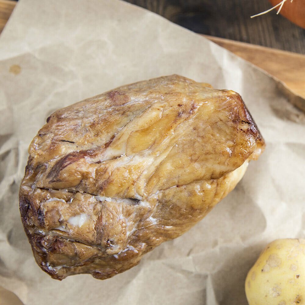 Raw smoked ham hock on butcher paper, ready for slow cooking