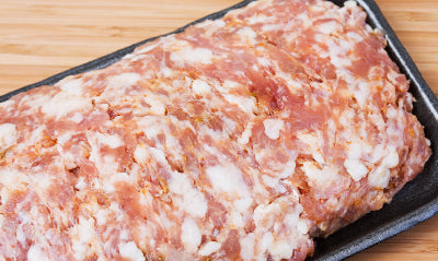 Raw mild Italian ground pork sausage on cutting board, unseasoned bulk style