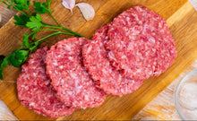 Raw pork patties on wooden cutting board, 4 oz each, ready to cook