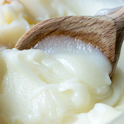 Rendered pork lard being scooped with wooden spoon, frozen and smooth