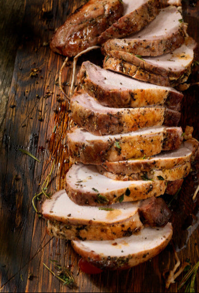 Roasted pork loin sliced on cutting board, cooked from local boneless pork roast